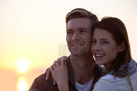 Photo for Love, hug and couple at ocean with sunset sky for tropical holiday adventure, relax and bonding together. Commitment, happy man and woman on romantic date with ocean, evening and embrace on vacation - Royalty Free Image
