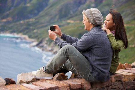 Téléchargez les photos : Couple heureux, selfie et photographie dans la nature en montagne pour l'image, la mémoire ou vlog en plein air. Vue arrière du sourire de l'homme et de la femme pour la photo, les médias sociaux ou le moment de collage à l'extérieur sur une falaise ou un mur. - en image libre de droit
