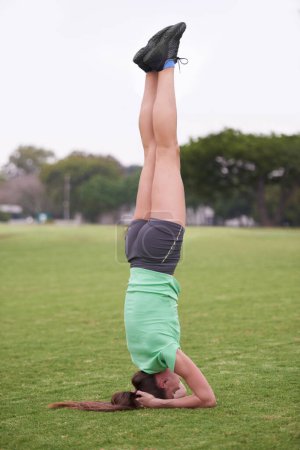 Photo for Headstand, sport and woman with fitness in a park with balance for wellness and health. Training, workout and outdoor on a field with exercise on a lawn with pilates and strong core practice. - Royalty Free Image
