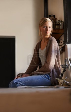Photo for Portrait, young woman and sitting at home, looking out the window relaxing. Face, smile and happy calm female person, chilling and peaceful on her kitchen counter in a house while positive on weekend. - Royalty Free Image