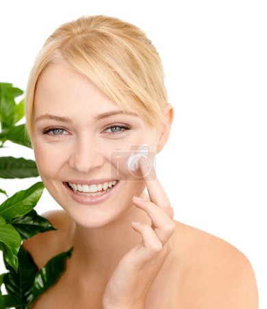 Photo for Lotion on face, leaves and woman with beauty for dermatology organic cosmetics and smile on white background. Portrait, cream or sunscreen with green plant for eco friendly skincare and moisturizing. - Royalty Free Image