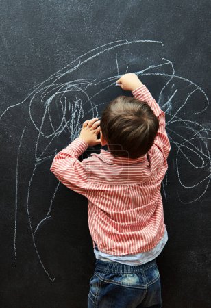 Photo for Young child, scribble and art on chalkboard in classroom of preschool for education of little boy. Kid, drawing and creative on blackboard with illustration for elementary, student and sketch. - Royalty Free Image