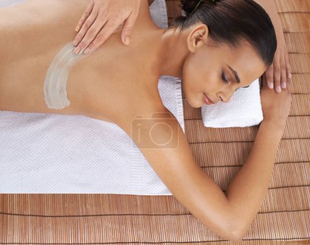Photo for Top view, hand and massage woman with mud for skincare, exfoliation or detox at table. Above, therapist and person at salon to pamper back, relax or healthy body treatment with masseuse at luxury spa. - Royalty Free Image