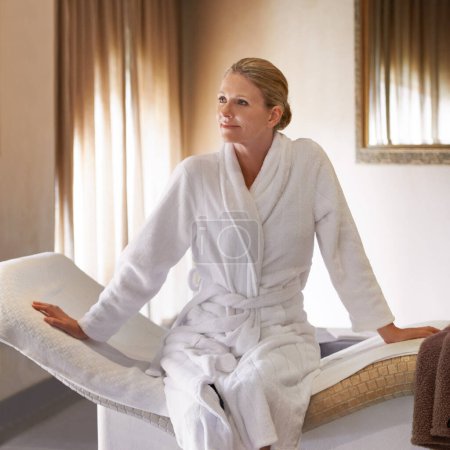 Photo for Woman, thinking and happy for spa treatment and wellness in robe, luxury and health on massage table or chair. Person or client relax in thoughtful expression, waiting and ready for holistic therapy. - Royalty Free Image
