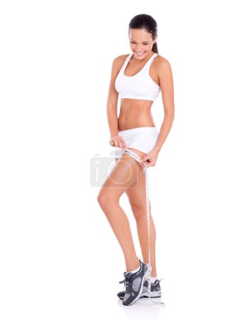 Téléchargez les photos : Ruban à mesurer, perte de poids et femme sur fond blanc pour le bien-être, le corps sain et l'alimentation. Sous-vêtements, personne heureuse et isolée mesurent les jambes pour la forme physique, l'exercice et les résultats d'entraînement en studio. - en image libre de droit