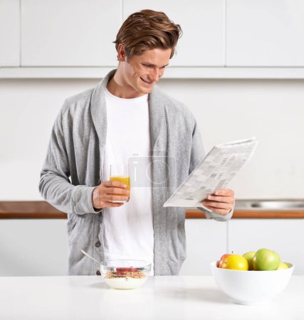 Foto de Desayuno, zumo y el hombre con periódico en la cocina para obtener información en el apartamento moderno. Nutrición, cereales y hombres jóvenes que beben bebidas saludables y leen el periodismo público en casa - Imagen libre de derechos