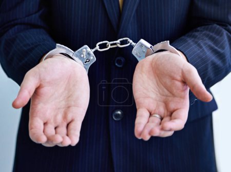 Photo for Hands, person in business and handcuffs for fraud or bribery, suspicious professional deal with justice or jail. Crime, corruption or money laundry, shackles for prison with thief or criminal. - Royalty Free Image
