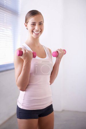 Photo for Woman, portrait and dumbbell for weight training in home with exercise, smile and workout. Happy, wellness and gym equipment for health and athlete with fitness for strength and confidence in house. - Royalty Free Image
