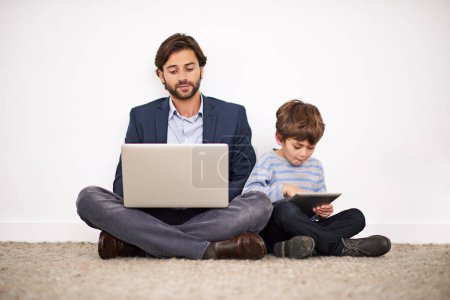 Photo for Father, laptop and kid with tablet on floor for learning, online education and relax at home. Child, dad and computer for internet, studying and family reading info on technology together by wall. - Royalty Free Image