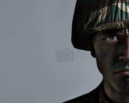 Photo for Man, portrait and soldier with camouflage for army, military war or battle on a gray studio background. Closeup of male person or commander with face paint or helmet in undercover disguise on mockup. - Royalty Free Image