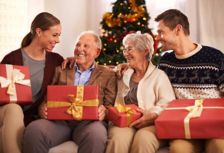 Photo for People, grandparents and family with Christmas gift for festive season together for celebration, presents or holiday. Elderly man, woman and couch at home in Canada for bonding, vacation or relaxing. - Royalty Free Image