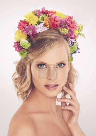 Photo for Woman, portrait or flower on crown in studio with makeup or confidence for cosmetics, beauty or skincare. Spring aesthetic, model and face or floral headband with glow or wellness on white background. - Royalty Free Image