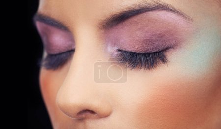 Photo for Eyes, makeup and woman with colorful and creative beauty in studio and black background. Unique, cosmetics and model with bold eyeshadow aesthetic on face to glow or shine with confidence in identity. - Royalty Free Image