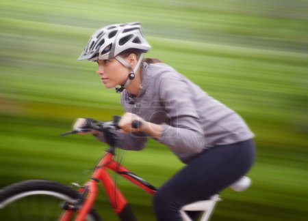 Téléchargez les photos : Femme, vélo et nature avec balade, vitesse et fitness pour la santé et le bien-être ou l'entraînement. Athlète, vélo et exercice pour l'entraînement, le transport et l'aventure avec casque pour le cardio et le flou de mouvement. - en image libre de droit