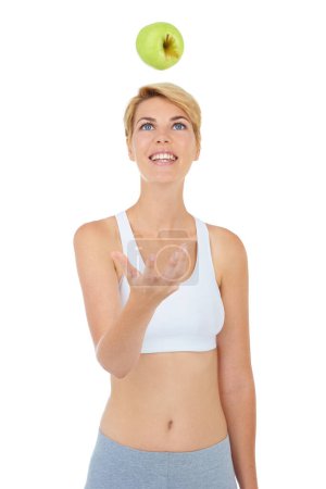 Healthy woman, apple and fitness in wellness studio, weight loss and nutrition with white background. Female model, diet and throwing fruit with fibre, active and happy for body health with mockup.