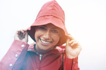 Photo for Happy woman, portrait and red rain jacket with hat for weather, cloudy sky or winter season in outdoor storm. Face of female person with waterproof coat and smile for protection, fog or cold overcast. - Royalty Free Image