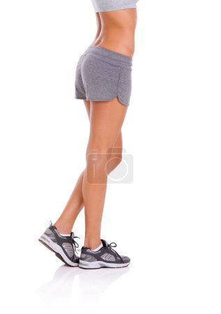 Photo for Woman, athlete and legs in studio with wellness for exercise, workout and healthy body with training shoes. Model, person and confidence with sportswear and shorts for fitness on white background. - Royalty Free Image