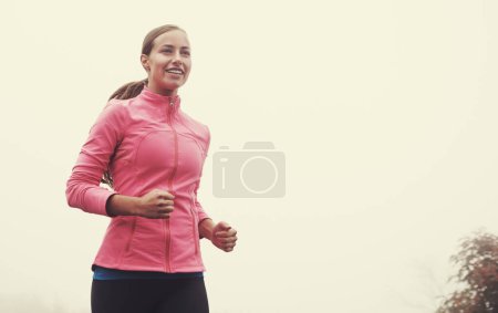 Photo for Nature, energy and woman athlete running on mountain road for race, marathon or competition training. Sports, exercise and female with cardio workout for fitness in misty outdoor woods or forest - Royalty Free Image