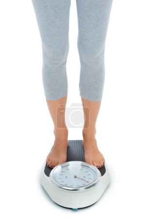 Photo for Woman, legs and scale in studio for weight loss, healthcare and wellness for vitality. Female person, diet and check calories for slim body for self care, achievement and closeup on white background. - Royalty Free Image