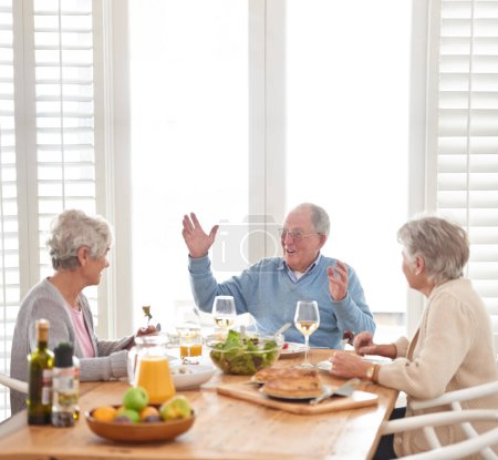 Photo for Wine, conversation and senior friends at lunch in home with smile, celebration and retirement. Food, drinks and bonding with memory, old man and women at dinner table together for happy brunch - Royalty Free Image