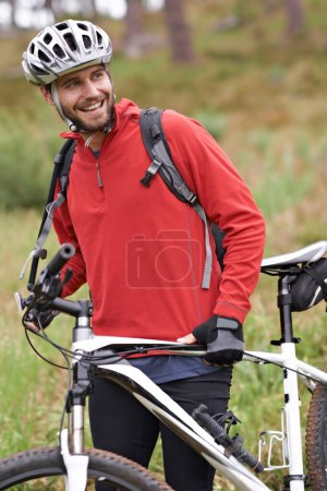 Photo for Smile, bike and man cycling in countryside for adventure, discovery or off road sports hobby. Fitness, health and wellness with happy young cyclist on bicycle in nature for cardio training or workout. - Royalty Free Image