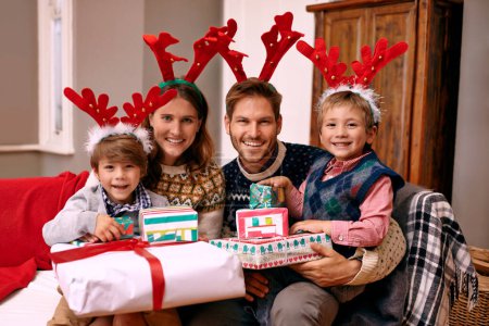 Photo for Portrait, smile and family with present for Christmas, holiday or together at festive celebration on sofa at home. Xmas, parents and happy children with gift in living room, face or antlers at party. - Royalty Free Image