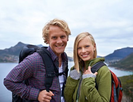 Photo for Happy couple, portrait and hiking with backpack on mountain for sightseeing, travel or outdoor journey in nature. Face of young man, woman or hikers carrying bag for trekking, fitness or adventure. - Royalty Free Image