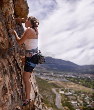 Photo for Woman, rope and rock climbing for fitness in outdoors, challenge and mountain for training. Female person, cliff and extreme sport for exercise or workout, equipment and support to explore in nature. - Royalty Free Image