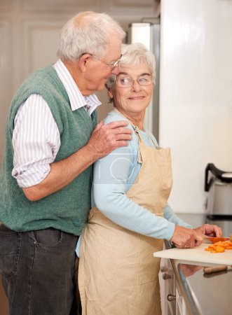 Photo for Senior couple, cutting vegetables and bonding in kitchen, food preparation and love at home. Elderly people, healthy meal and organic ingredients or carrots for nutrition, conversation and retirement. - Royalty Free Image
