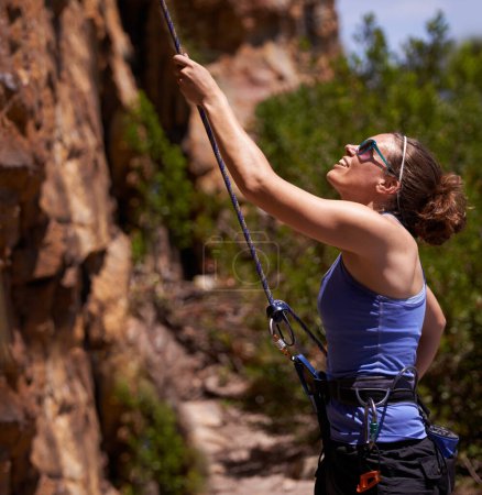 Foto de Mujer feliz, escalador y montaña con cuerda para escalada, senderismo o trekking sobre rocas en la naturaleza. Persona femenina o excursionista con sonrisa y arnés para agarre, seguridad o deportes extremos en desafío fitness. - Imagen libre de derechos