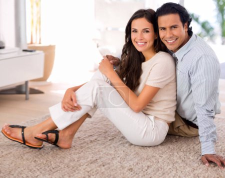 Photo for Happy, love and couple on carpet in living room at home with comfortable romance and care. Smile, marriage and portrait of young man and woman relaxing on floor mat together in lounge at house - Royalty Free Image