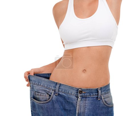 Photo for Jeans, stomach and woman in studio with weight loss for health benefits, diet and fitness goals. Female person, pants and body transformation on white background for progress, results and comparison. - Royalty Free Image