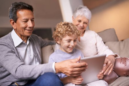 Photo for Happy family, grandparents and little boy with tablet for entertainment, social media or research on sofa at home. Grandma, grandpa and child smile on technology for online search or movie at house. - Royalty Free Image