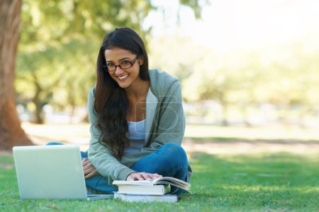 Photo for Laptop, student or happy woman in nature reading book for learning knowledge, information or education. Research, textbook or person in park on grass for studying or typing online on college campus. - Royalty Free Image
