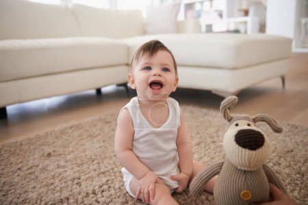 Photo for Baby, teddy bear and toy on living room floor or morning playing in home for resting development, childhood or happiness. Kid, boy and lounge in apartment by couch for weekend joy, fun or relaxing. - Royalty Free Image