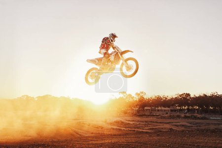 Photo for Person, jump and motorcyclist with sunset for trick, stunt or ramp on mockup or outdoor dirt track. Expert rider on motorbike in the air with lift off for extreme sports or rally challenge in nature. - Royalty Free Image