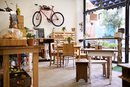 Photo for Interior, bike on wall of empty coffee shop with tables and chairs for retail, service or hospitality. Space, small business or startup restaurant with cafeteria seating for bistro consumerism. - Royalty Free Image