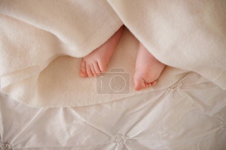 Photo for Baby, feet and toes or blanket on bed for childhood development or nursery sleeping, relax or resting. Kid, wellness and childcare as closeup for wellbeing nap or dreaming nurture, caring or calm. - Royalty Free Image