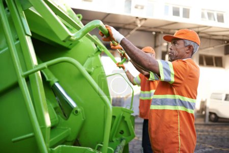 Photo for Trash, waste management and garbage truck with men in uniform cleaning outdoor on city street. Job, service and male people working with rubbish for sanitation, maintenance or collection of dirt - Royalty Free Image