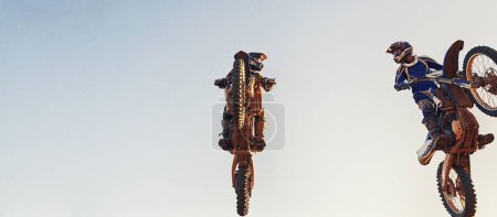 Photo for Sky, jump and men on motorcycle together for stunt at competition, training or challenge with banner mockup. Adventure, professional or athlete in air on motorbike for hobby, extreme sports or trick - Royalty Free Image