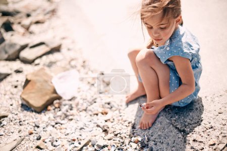 Photo for Child, beach and sea shells or search nature to explore environment for summer holiday, weekend or vacation. Female person, fishing net and wind at Florida seaside for travel, adventure or playing. - Royalty Free Image