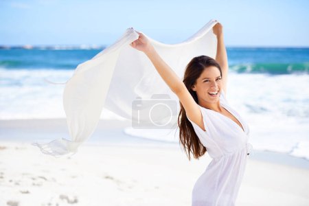 Photo for Portrait, happy woman and fabric in wind at beach outdoor for summer, vacation and travel on holiday. Ocean, smile and person fly with scarf in the air for adventure, freedom and sea breeze by water. - Royalty Free Image