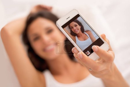 Photo for Woman, selfie and phone screen in morning, bed and relax with photography on web blog. Girl, person and influencer for profile picture, click and ux for live streaming in bedroom on social network. - Royalty Free Image