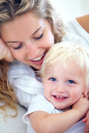 Téléchargez les photos : Portrait, maman et bébé se lient à la maison avec le sourire, le soutien et le temps de qualité avec le bien-être familial heureux. Détendez-vous, mère et visage de tout-petit fils avec amour, croissance et développement de l'enfant dans l'appartement - en image libre de droit