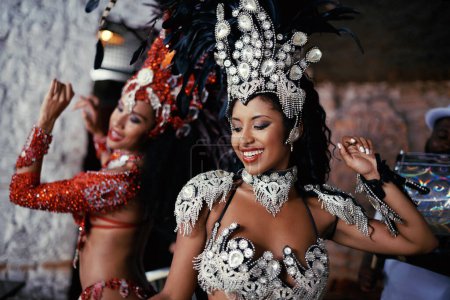 Samba, festival and women in costume together for celebration, music culture and happy band in Brazil. Dance, party and girl friends with smile at carnival, parade or stage show in Rio de Janeiro.