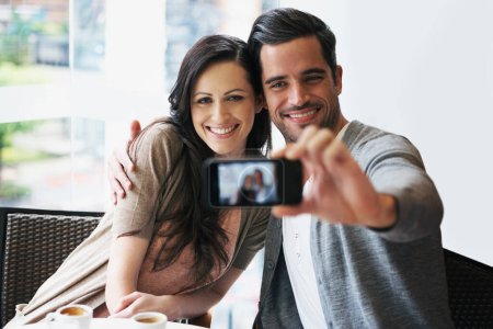Photo for Couple, smile and date at cafe taking selfie for posting, blog or happy in restaurant with coffee, tea or latte. People, bonding or love together for pictures for social media, online or indoors. - Royalty Free Image