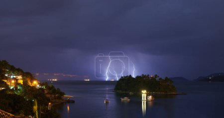 Photo for Thunderstorm, sea and land with bad weather, nature and raining with storm and New York city. Clouds, climate change or ocean with lightning or night with warning or island with winter, dark or water. - Royalty Free Image