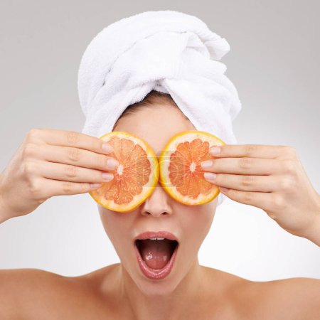 Photo for Skincare, wow and woman with towel, grapefruit and spa treatment with cosmetics in studio. Dermatology, healthy skin and face of girl on white background with shock, vitamin c and natural beauty - Royalty Free Image