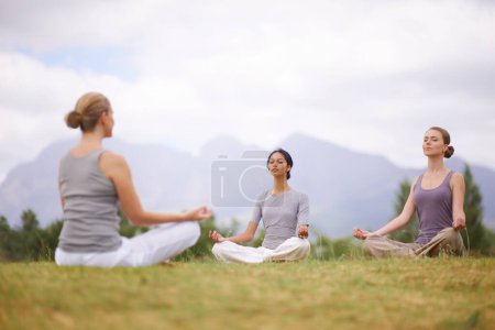 Téléchargez les photos : Lotus, instructeur et méditation en plein air pour le yoga, le corps sain et l'exercice de pleine conscience pour se détendre. Paix, groupe et calme des femmes en padmasana dans la nature pour l'équilibre, la spiritualité ou respirer ensemble. - en image libre de droit