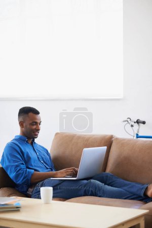 Photo for Man, laptop and freelancer for remote work at home, plan and copywriting in living room. Black male person, mockup space and connection for research on website, information and typing an article. - Royalty Free Image